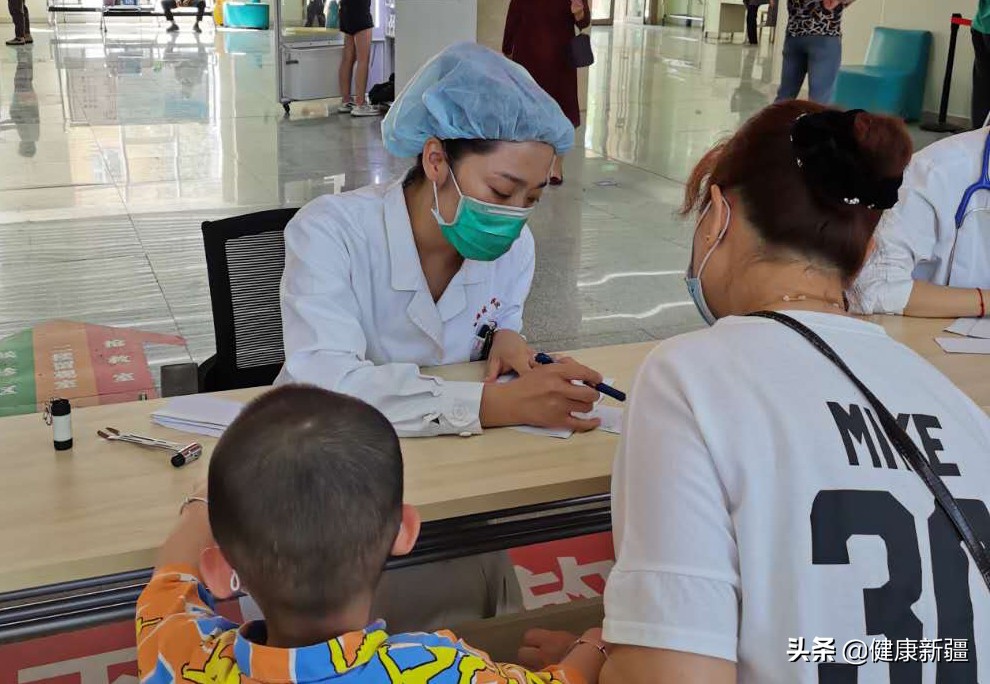 图9义诊现场专家为小朋友分析病情 图9义诊现场专家为小朋友分析病情