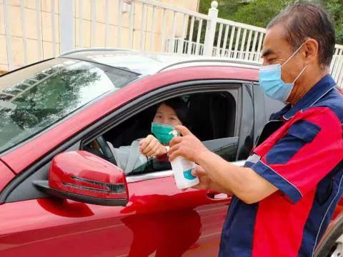 图1-2安检人员为来院停车患者进行手消毒 图1-2安检人员为来院停车患者进行手消毒